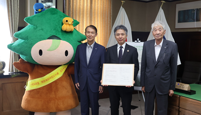 At the signing ceremony. From left, Shuhei Kishimoto, Governor of Wakayama Prefecture; Kenshi Matsubara, Director & Executive Vice President at transcosmos inc.; Masataka Nakayama, Mayor of Aridagawa Town *Left corner: KINO-PI, a mascot for KINOKUNI Hometown Creation & KINOKUNI Forest Creation Ambassador