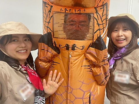 ティラノサウルスのコスプレをした男性と探検隊のコスプレをした女性ふたりがポーズをとっている